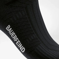 Närbild på Arch Support Zone och Bauerfeind-logga, svart strumpa